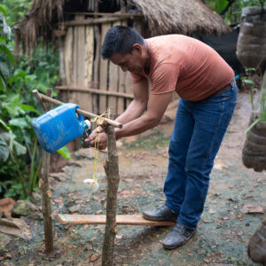 A man washes his hand at a handwashing station