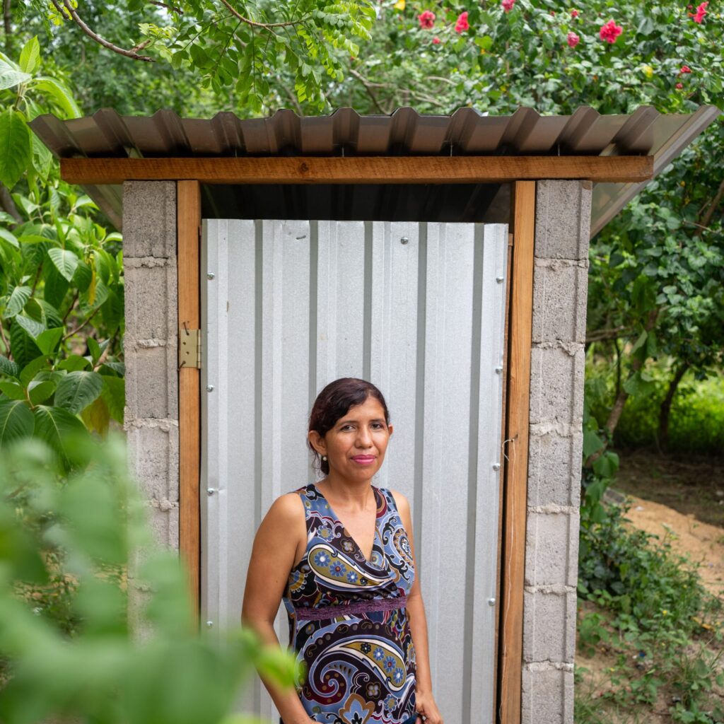 woman standing in front on latrine