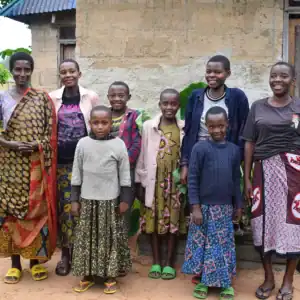 Free A Family family members standing together outside their home.