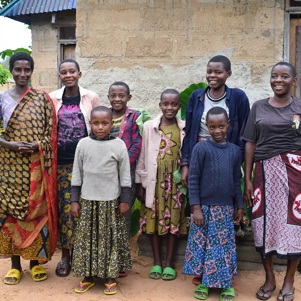 Free A Family family members standing together outside their home.