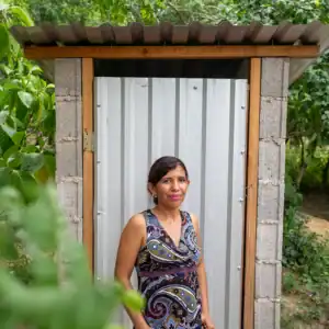 Person standing in front of a newly constructed outdoor latrine.
